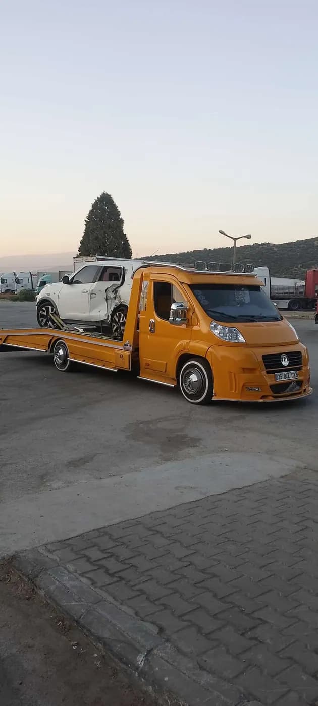 Sarı çekici üzerinde beyaz otomobil taşıma