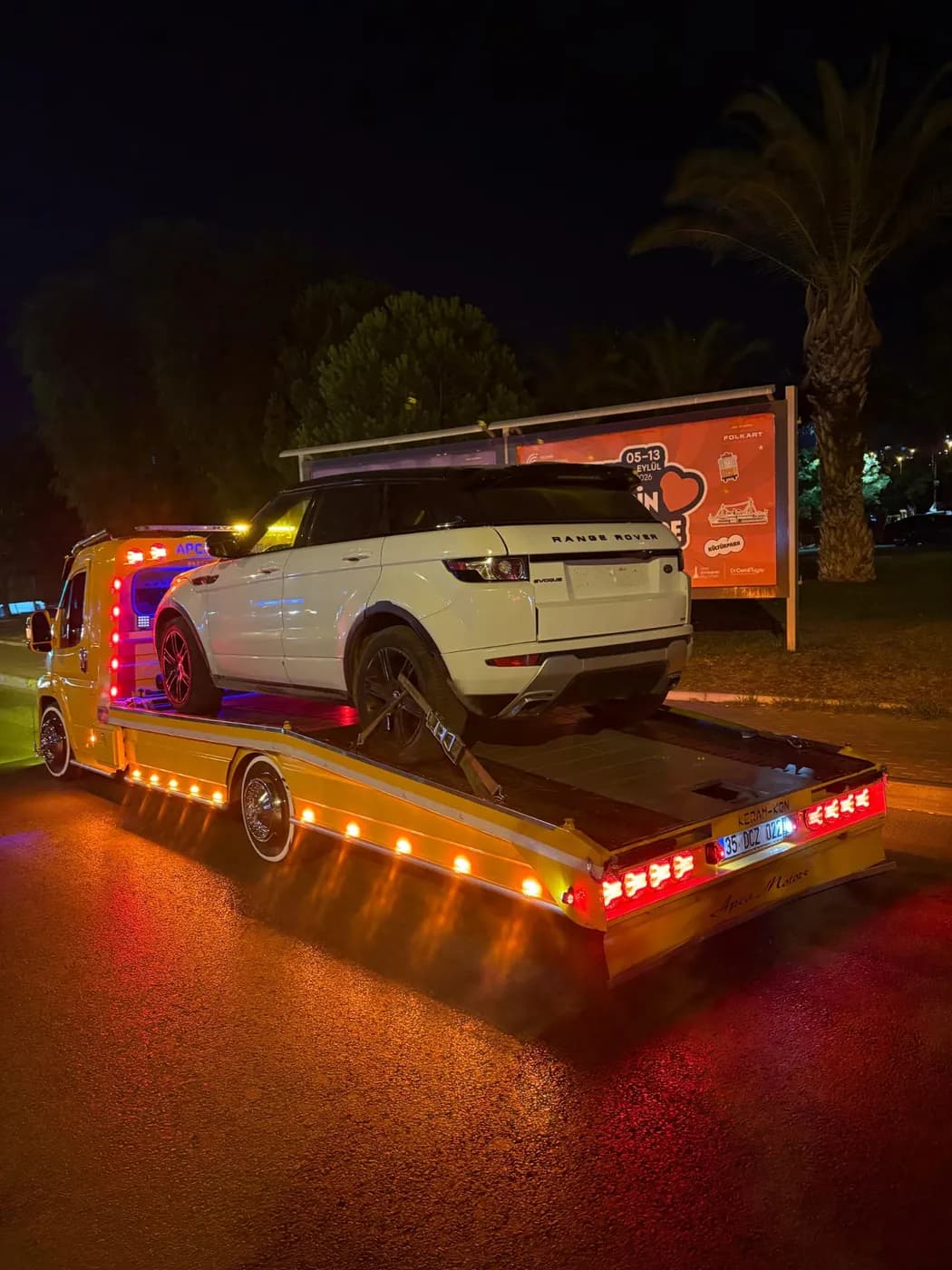 Gece sarı platform çekici üzerinde beyaz SUV