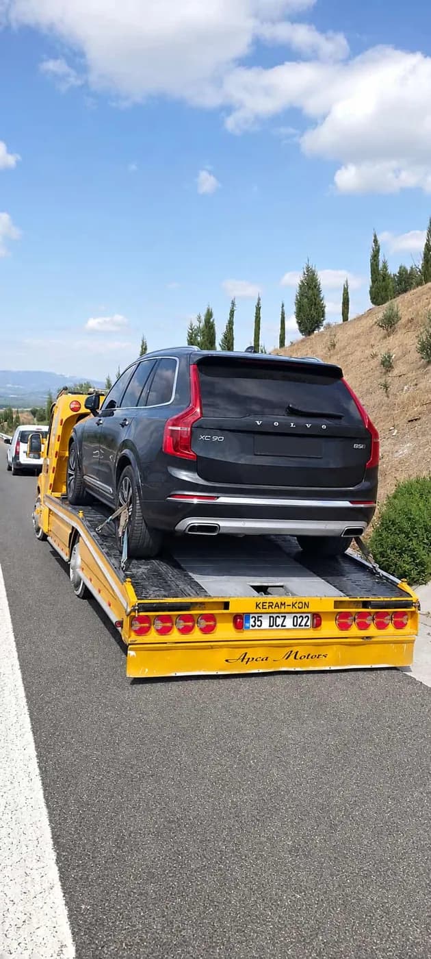 Sarı platform çekici üzerinde taşınan siyah SUV